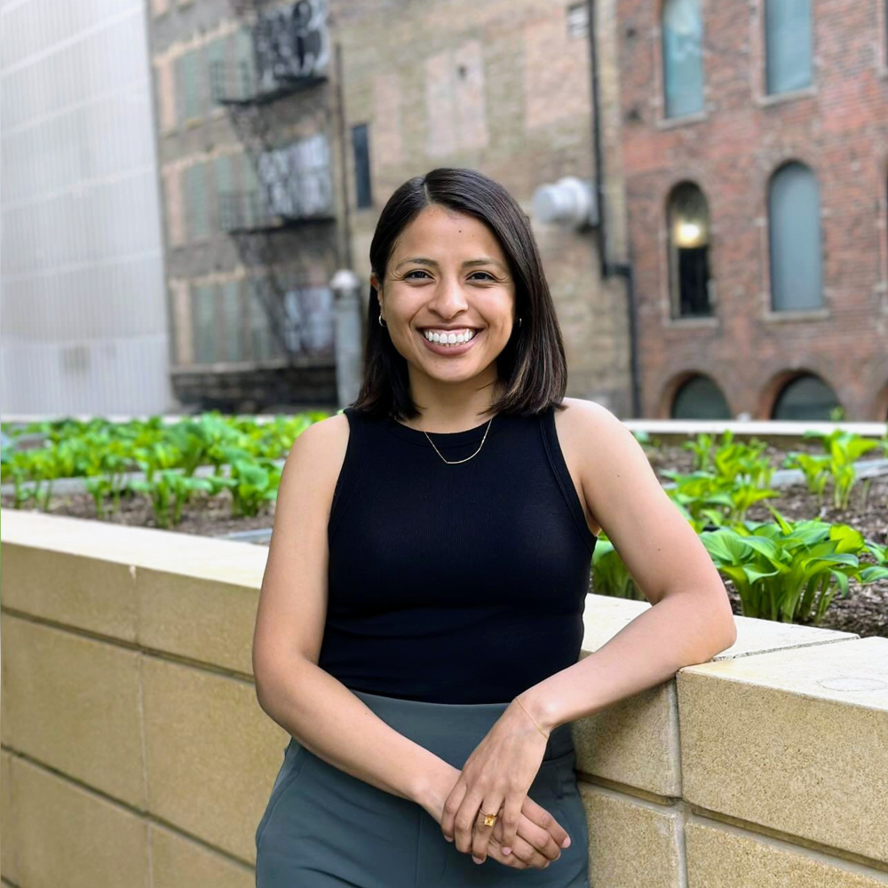 Jelanny Ramirez Pavón stands outdoors on a campus terrace, smiling.